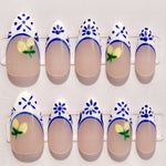 Nail art with blue floral designs and yellow flowers on a white background