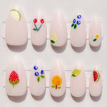 Set of white nail art designs with colorful floral and fruit patterns on a white background