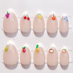 Set of nails with fruit-themed decorations on a white background