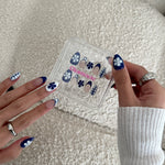 Nail art design set with matching nail designs on hands against a neutral background