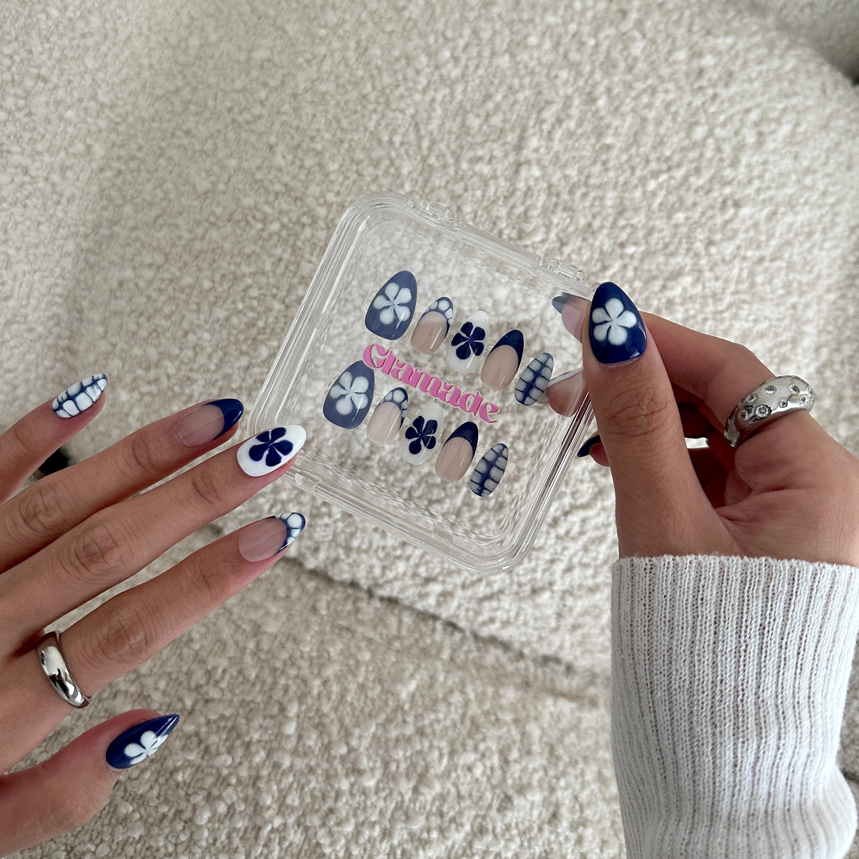 Nail art design set with matching nail designs on hands against a neutral background