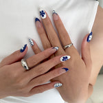 Close-up of hands with decorative nail art on a white background