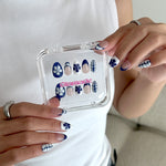 Nail art display case with floral nail designs held by a person wearing matching nail polish.