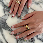 Close-up of hands with Press on nail art on a marble surface