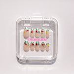 Set of decorative false nails in a clear plastic case on a light gray background